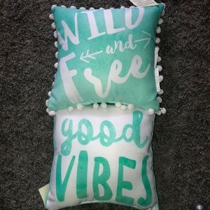 Throw pillows. One says wild and free and the other one says good vibes